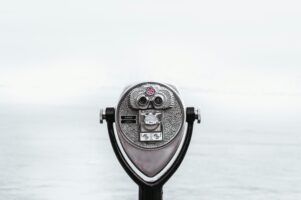 Coin-operated binoculars facing a foggy seascape, symbolizing the exploration of data visibility with Looker.