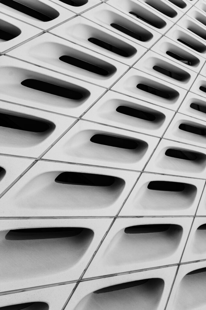 Close-up of an abstract architectural facade with geometric patterns and dark openings