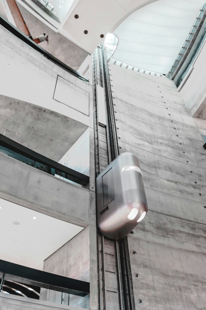 Modern glass and concrete building interior with an elevator